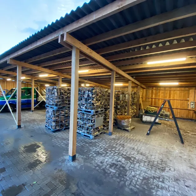 Verlichting die onder de bestaande houten overkapping is geplaatst.